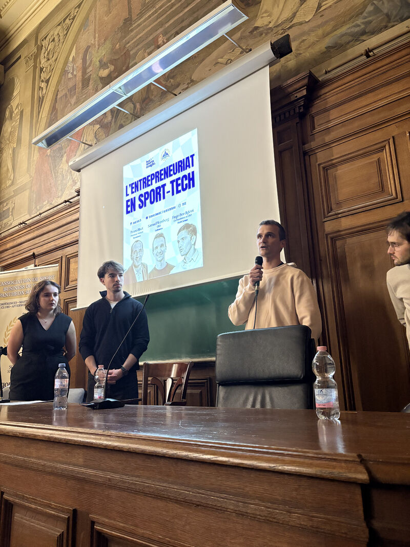 Un intervenant prend la parole debout au micro pour ouvrir la table ronde