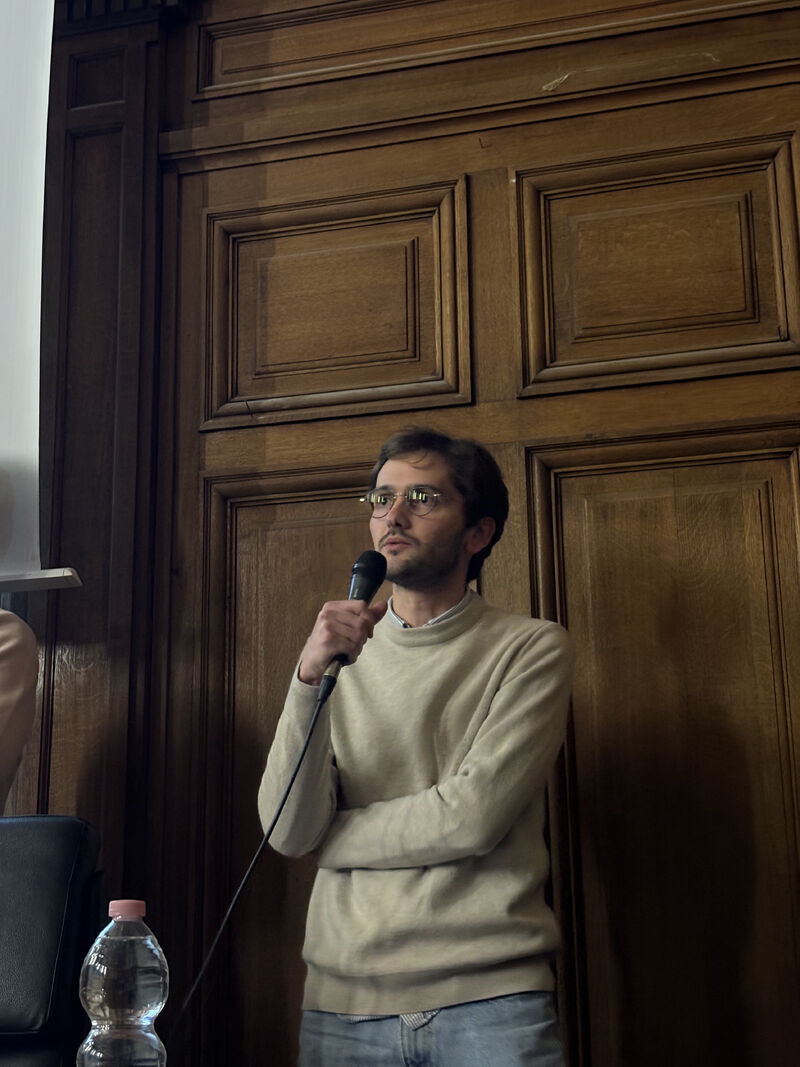 Un intervenant r&eacute;pond au micro devant les boiseries de l&rsquo;amphith&eacute;&acirc;tre