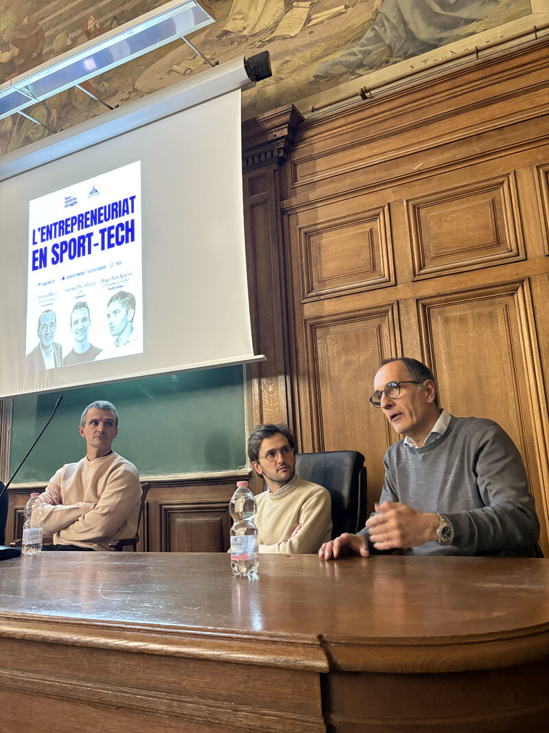 Les trois intervenants de la table ronde assis &agrave; la tribune, devant l&rsquo;affiche de l&rsquo;&eacute;v&eacute;nement