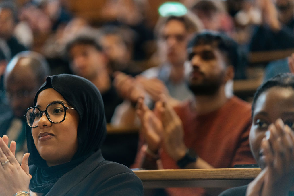 Des étudiantes et étudiants applaudissent au premier rang