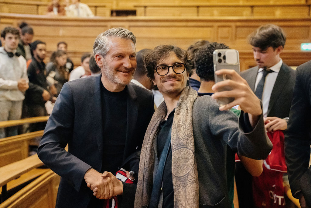 Olivier Létang salue un étudiant et pose pour une photo à la fin de la conférence
