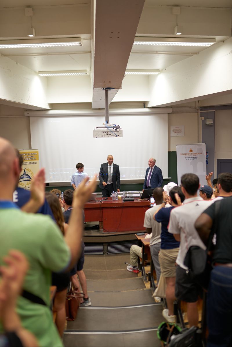 Le public applaudit debout à la fin de la conférence